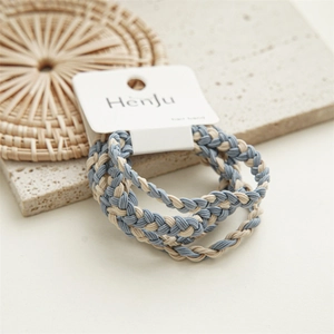 Detail of three-strand braided hair bands in mist blue and beige on display card