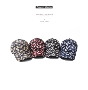 Close-up of baseball caps in four colors featuring floral patterns and curved brims