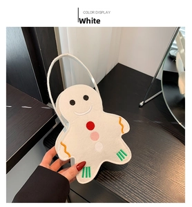 Détails de broderie sur un sac de Noël en feutre blanc en forme de bonhomme de pain d'épices