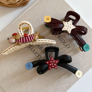 Detailed macro view of acrylic hair claws with cute star, puppy, and bow decorations