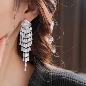 Detail of silver long tassel earrings with sparkling zircon stones worn by a model