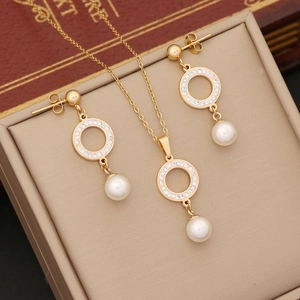 Golden necklace and earring set featuring crystal halos and white pearl pendants