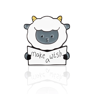 Cute lamb enamel pin holding a Make a wish sign on a clean white background