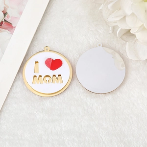 Macro shot of gold-plated I Love Mom heart pendant with hollow letters and red enamel
