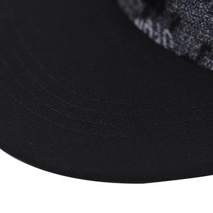 Macro shot of reinforced stitching on the black twill visor of this hip hop baseball cap