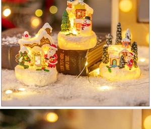 Three miniature Christmas resin houses with warm LED lights and snowman decorations