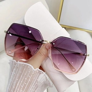 Close-up of frameless geometric sunglasses with purple gradient lenses and gold temples
