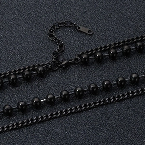 Close-up of layered black bead necklace with stainless steel links and lobster clasp