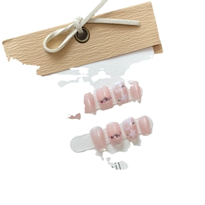 Pink cat-eye press-on nails with glitter, white stars, and gemstone rhinestones