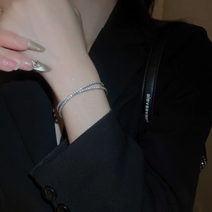 Vue détaillée du bracelet croisé argenté serti de zircons brillants sur le poignet