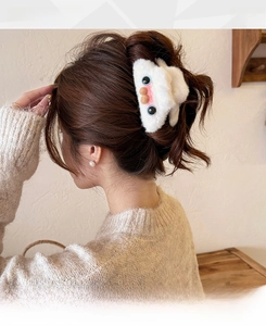 Detail of plush cat shark clip with cute eyes and pink nose on model's soft hair