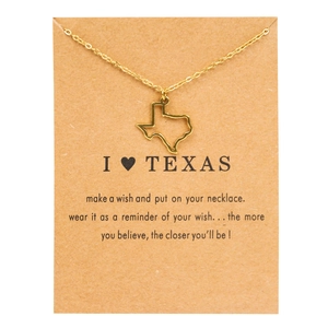 Close-up of golden Texas state map pendant necklace on brown kraft wish card