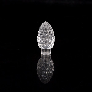 Macro shot of a transparent pine cone crystal ornament on a black reflective background