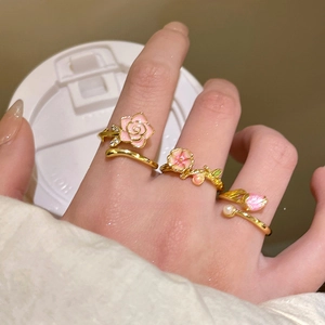 Close-up of 18k gold plated flower rings with pink enamel, zircons and pearls