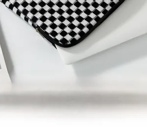 Detail of checkered knit laptop sleeve featuring thick texture and durable black zipper