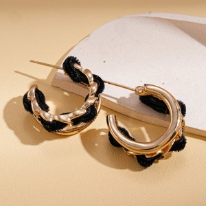 Boucles d'oreilles créoles dorées avec chaîne en velours noir sur fond pierre