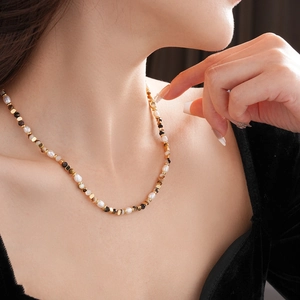 Dettaglio della collana vintage con perle d'acqua dolce e pietre naturali sul collo