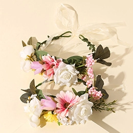 Detailed view of handmade floral headbands with realistic white and pink roses and berries