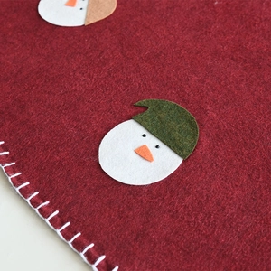 Red felt Christmas tree skirt featuring a white snowman applique with festive embroidery
