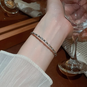 Detail of silver bamboo style bracelet with cubic zirconia on a woman's wrist