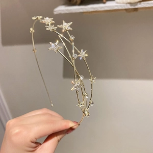 Detail of gold star headband featuring layered stars with pearls and sparkling rhinestones