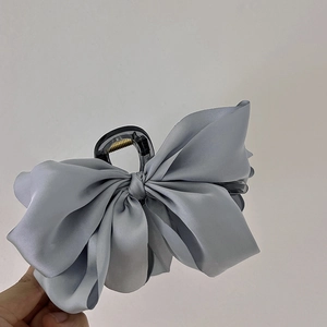 Detail showing high-end silver grey satin bow texture on the premium hair claw clip
