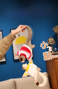 Close-up of sugar glider plushies wearing knit sweaters in red and yellow stripes