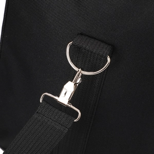 Macro detail of the durable metal D-ring and swivel snap hook on the black travel bag