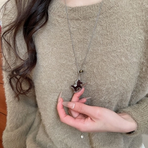Détail du collier avec pendentif poney floqué et une petite perle sur une chaîne argentée