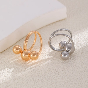 Macro view of polished double-layer stainless steel rings with glossy triple-sphere design