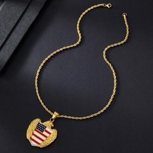 Detail of eagle clutching American flag shield pendant on a gold rope chain