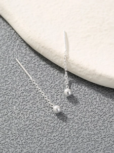 Elegant silver round bead tassel threader earrings shown on minimalist stone decor