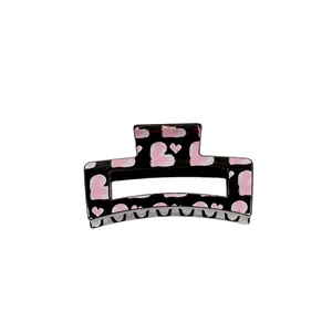 Square black hair claw with pink heart patterns for elegant hair styling and grip