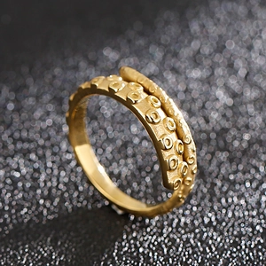 Macro shot of gold octopus tentacle ring detail showing suction cup textures and metal finish