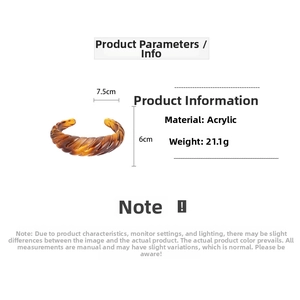 Detail view of amber acrylic bangle with spiral texture and 7.5cm width measurement