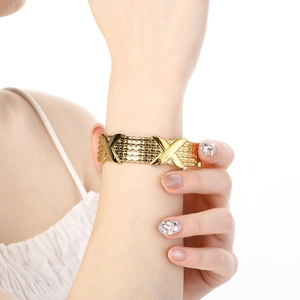 Detailed view of an 18K gold-plated woven mesh bracelet with X-shaped polished design