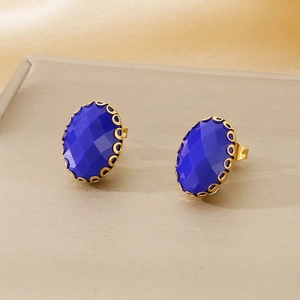 Macro shot of oval blue glass stud earrings with intricate gold basket claw setting