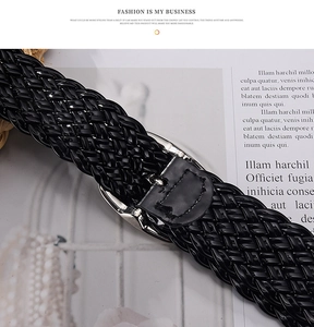 Close-up of black braided patent leather dress belt with a silver metal needle buckle