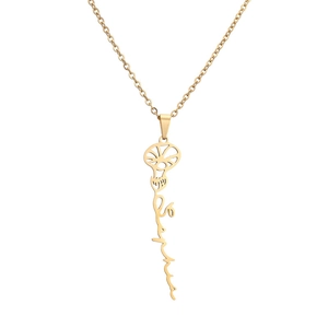 Macro detail of gold stainless steel necklace with floral design and cursive lettering