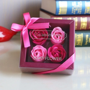 Detail of four pink soap flower roses in a transparent gift box with a pink ribbon bow