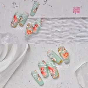 Detail of mint green nail stickers featuring koi fish, cherry blossoms and gold embossing
