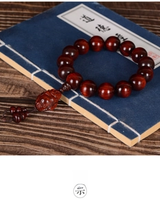 Close-up of red sandalwood beads with Maitreya Buddha pendant on Tao Te Ching book