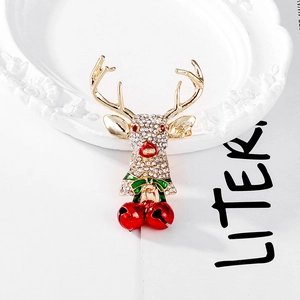 Vintage Christmas elk brooch with rhinestone inlay and red bells on white decorative tray