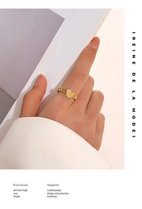 Detailed view of a gold heart chain ring on finger with elegant minimalist styling