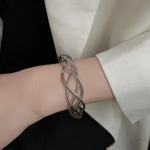 Irregular silver hollow twisted open cuff bracelet with layered wavy metallic design