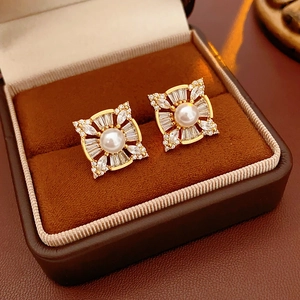 Detail of square floral pearl earrings with zircon stones in a velvet box