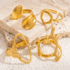 Set of four gold geometric irregular open rings made of stainless steel on stone
