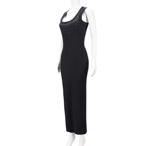 Close-up of sparkling rhinestones on the square neckline of a black ribbed knit dress