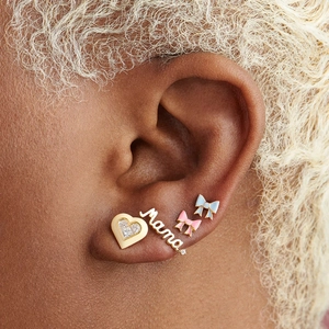 Detail of S925 silver earring set with heart, Mama text, and enamel bow studs on ear