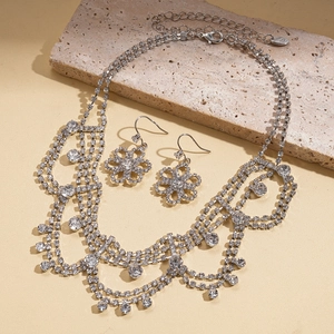 Detailed macro view of layered rhinestone necklace and snowflake pendant earrings